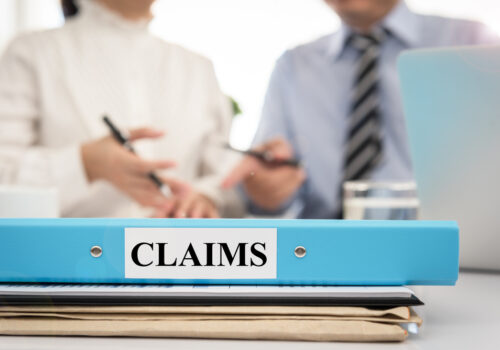 shutterstock_476242027 claims folder with people in background photo